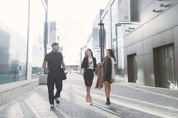 People walking into a modern office building, suggesting increased hiring and a competitive job market.