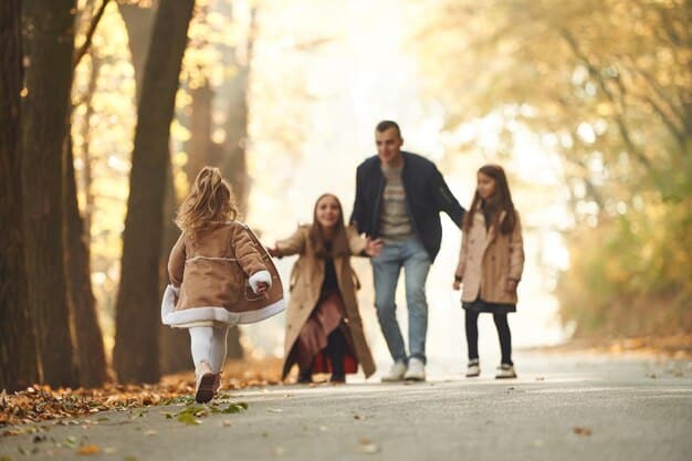A young family, including parents and two children, smiling and holding hands while walking in a park. The scene is filled with natural light, conveying a sense of happiness, security, and the importance of family unity.