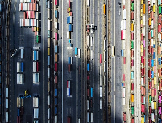An image showcasing a variety of shipping containers at a bustling US port, with trucks and cranes actively moving cargo. The image emphasizes the busy import/export activity and the importance of compliance in the logistics process.