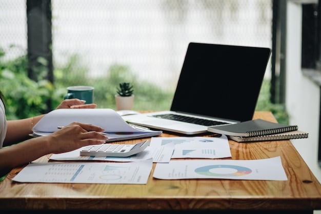 A person reviewing financial documents at a desk with a laptop, highlighting the importance of thoroughness in year-end tax planning strategies for businesses.