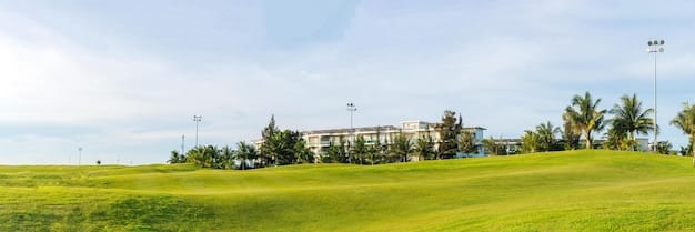 A wide shot of a residential area nestled next to a pristine green golf course. Houses are visible with well-manicured laws meeting seamlessly with golf course grass. The scene captures the essence of luxurious golf course living in the US. The image enhances the section 'The Rise of Golf Course Communities'.