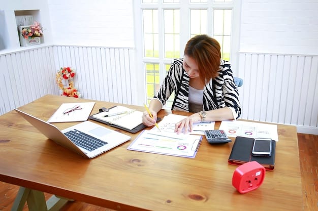 A person using a calculator and reviewing loan documents at a table. There are a variety of pamphlets and flyers spread out on the table representing Financial Aid 101: Understanding Grants, Loans, and Work-Study Programs for 2025.