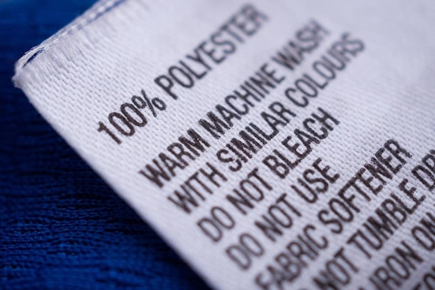 A detailed close-up of a textile label showing information about fiber content, country of origin, and care instructions, illustrating the importance of accurate labeling for textile imports to the US.